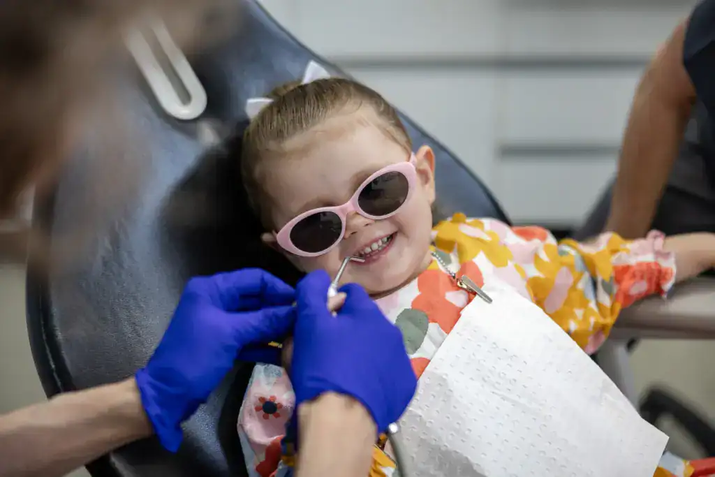 A child in the chair wearing protective sunglasses