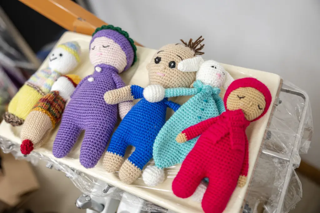 Hand-crocheted dolls on a tray in the surgery