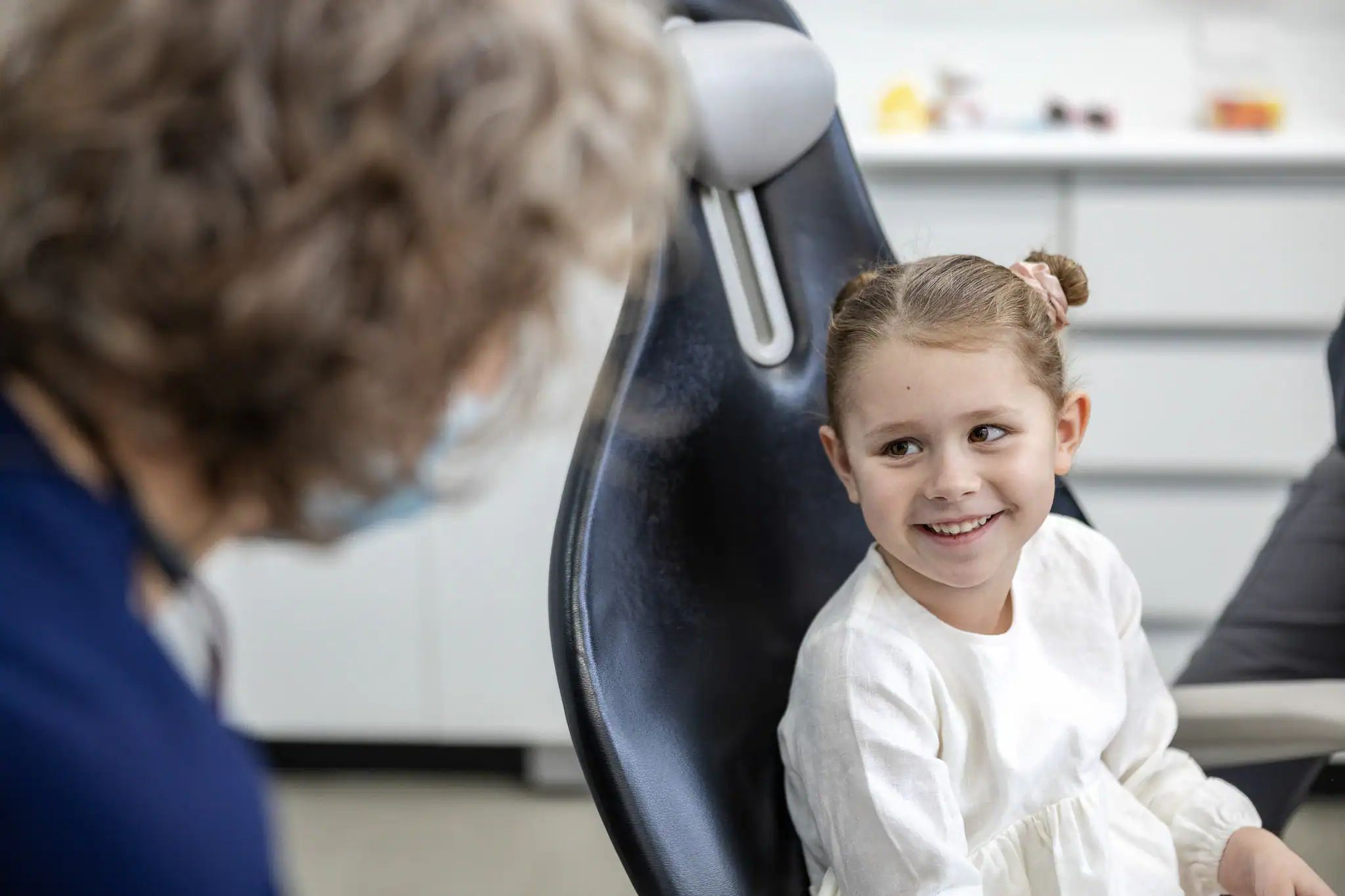 Dentist treating a young child in the surgery